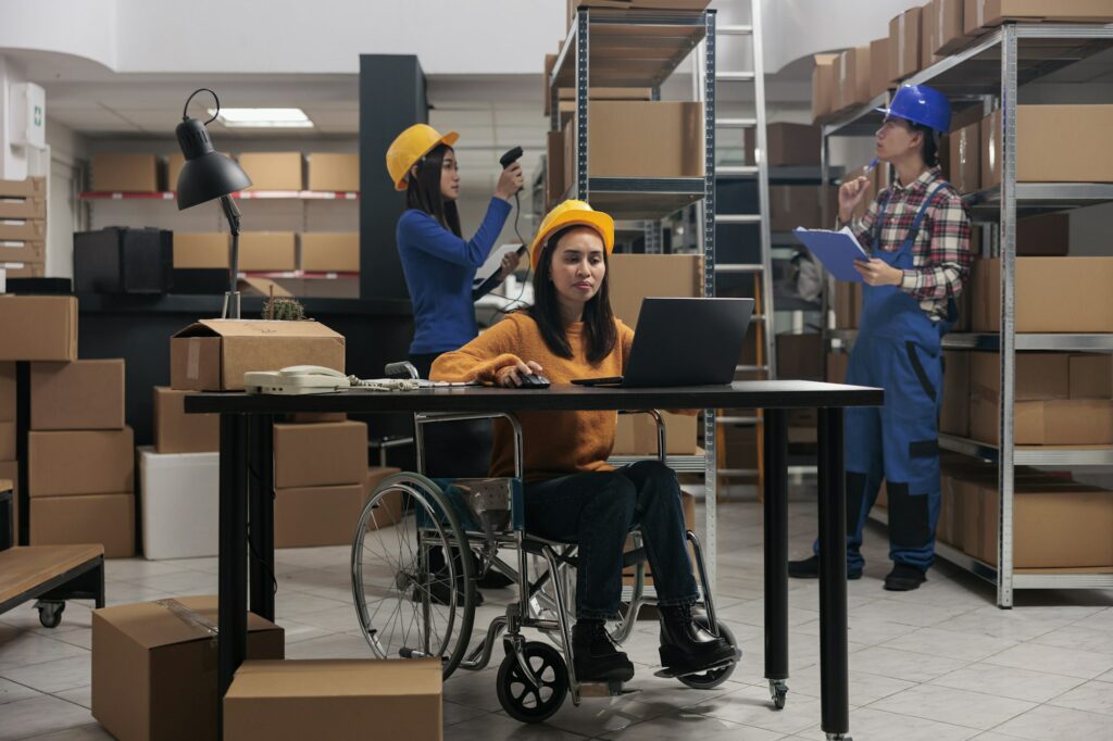 Warehouse employee doing office work in disability friendly workplace